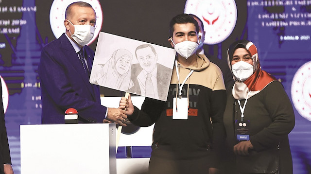 Törende salonda bulunan bir genç, Cumhurbaşkanı Erdoğan’a annesi Tenzile Erdoğan ile bir fotoğrafının kara kalem çalışmasını hediye etti.