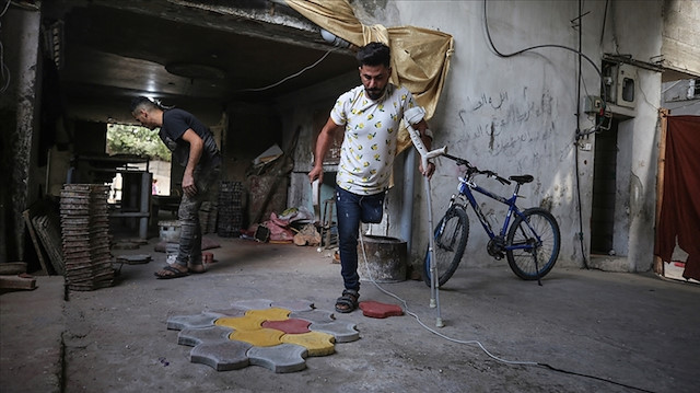 "حسام جربوع".. فلسطيني يهزم الإعاقة بصناعة بلاط المباني 