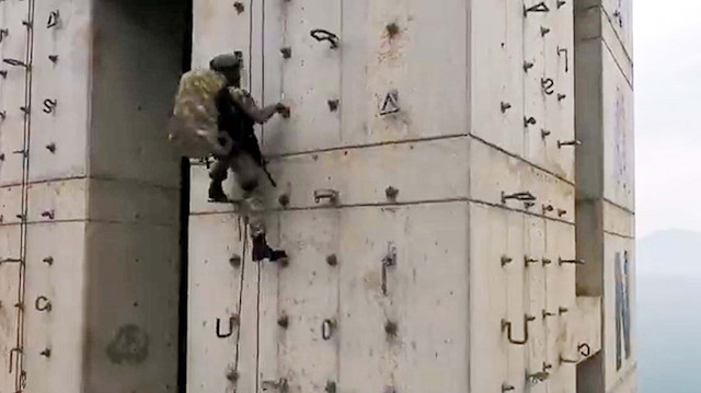 Videoda komandoların, binanın duvarından iple inerken, aynı zamanda silah kullandığı ve hedefe ateş ettiği görüldü.