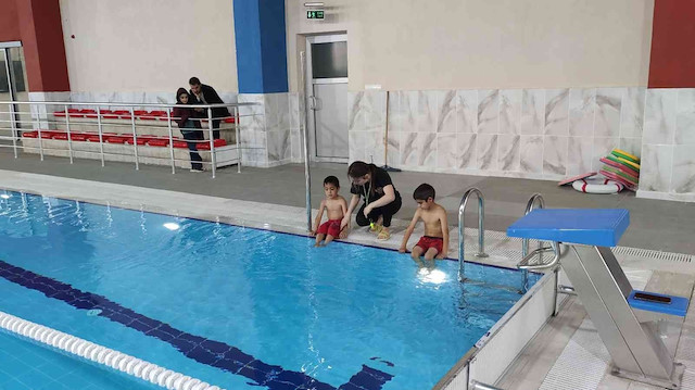 Yüzme salonunda çocuklar eğitiliyor.