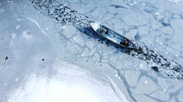 Eksi 11 derecede ekmek mücadelesi: Donan gölde buzları kırarak ilerliyorlar