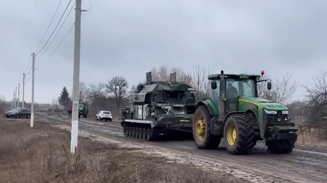 Ukraynalı çiftçiler ele geçirdikleri Rus ordusunun tanklarını traktörle çekti