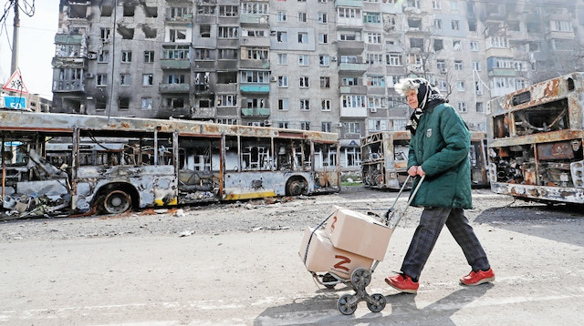 Yaşlı bir Mariupol sakini, el aracıyla insani yardım kolisini evine götürmeye çalışıyor.