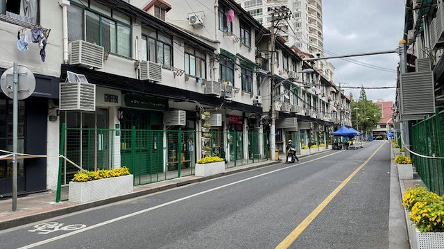 Yeşil çitler, bir Şanghay caddesindeki dükkan ve konutların girişlerini kapatıyor.