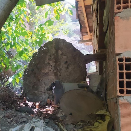 Dağdan kopan kaya parçaları bir evin çatısı ve bahçesine düştü