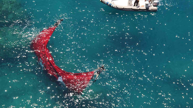 Antalya'da denize düşen dev Türk bayrağını polisler çıkardı