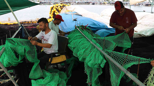 Balıkçılar, yırtılmış ağlarını tamir ederek ve teknelerinin bakımını yaparak son hazırlıklarını yapıyor. 