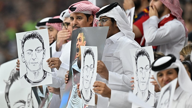 Katar'daki futbolseverler, Almanya Milli Takımı'nı ırkçı saldırılara maruz kalan Mesut Özil'in posterleriyle protesto etti .