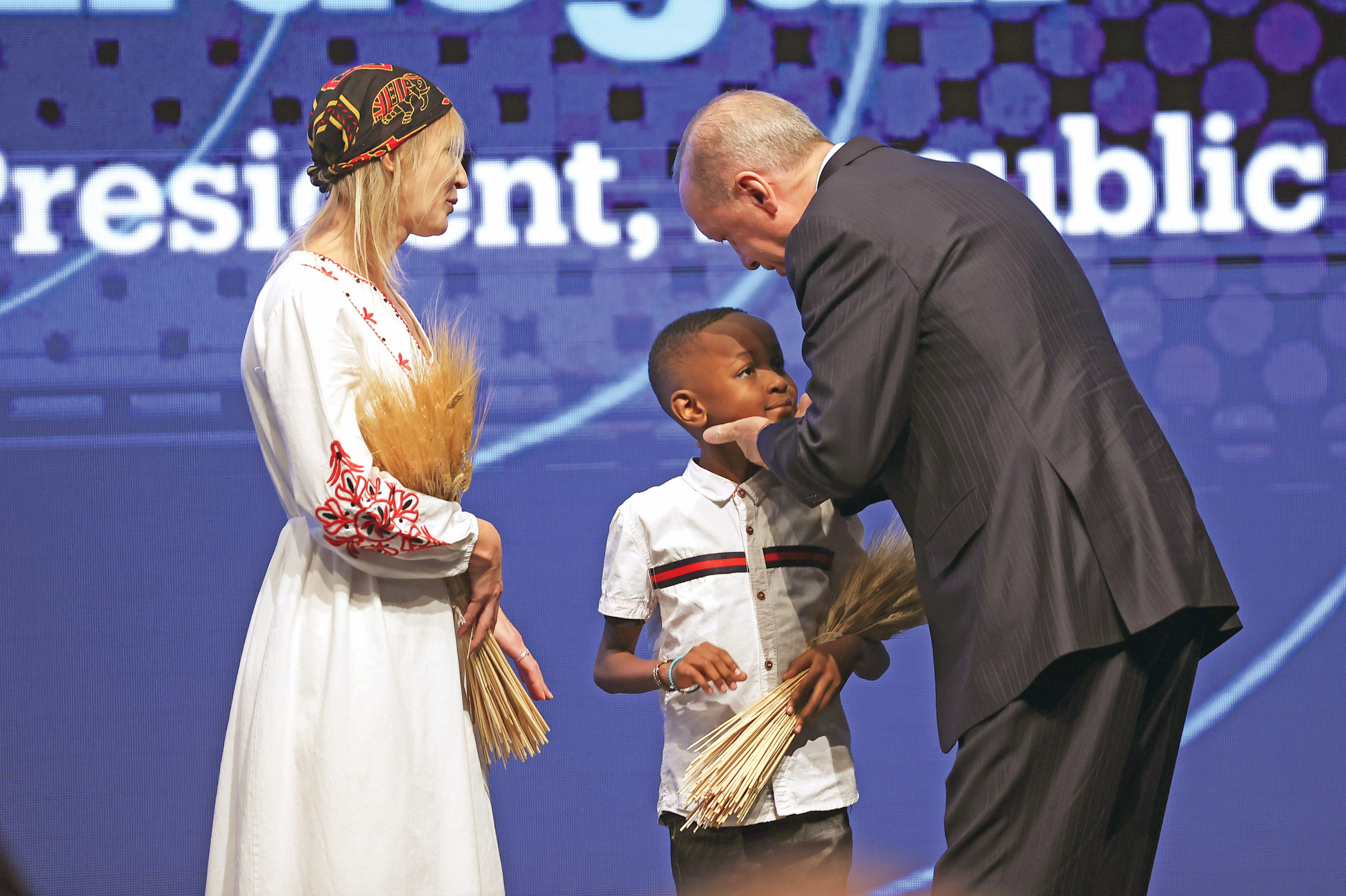 Cumhurbaşkanı Erdoğan’a, Ukraynalı bir kadın ve Afrikalı bir çocuk tarafından buğday başağı takdim edildi.