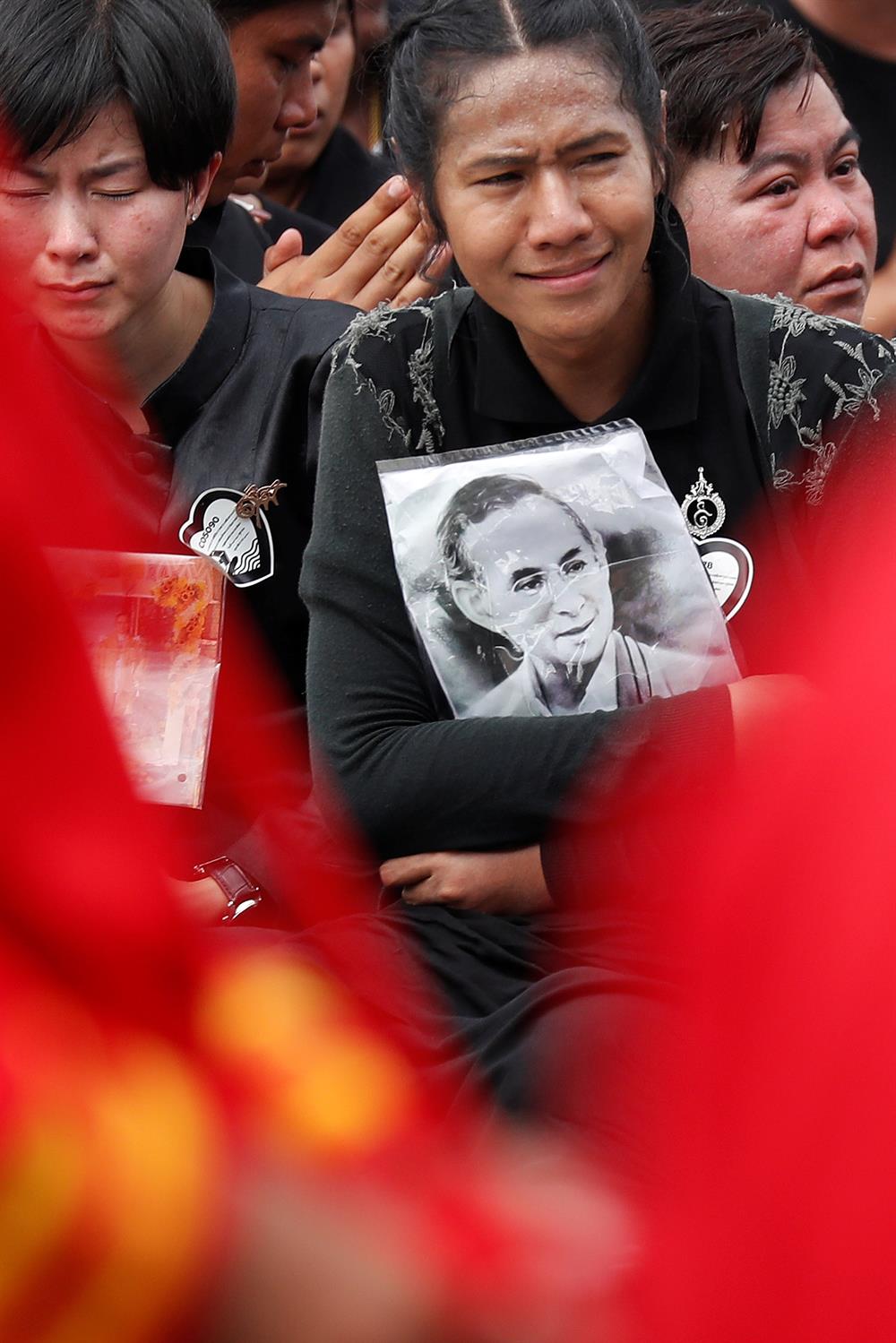 Mourners react as the Royal Urn of late King Bhumibol Adulyadej is taken by the Great Victory Chariot during a royal cremation procession at the Grand Palace in Bangkok, Thailand.