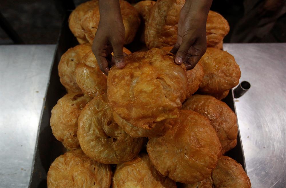 A worker sets "khajla", a traditional delicacy consumed during the month of Ramadan, while selling them from a stall along a road ahead of Muslim holy month of Ramadan in Karachi, Pakistan, May 25, 2017. 