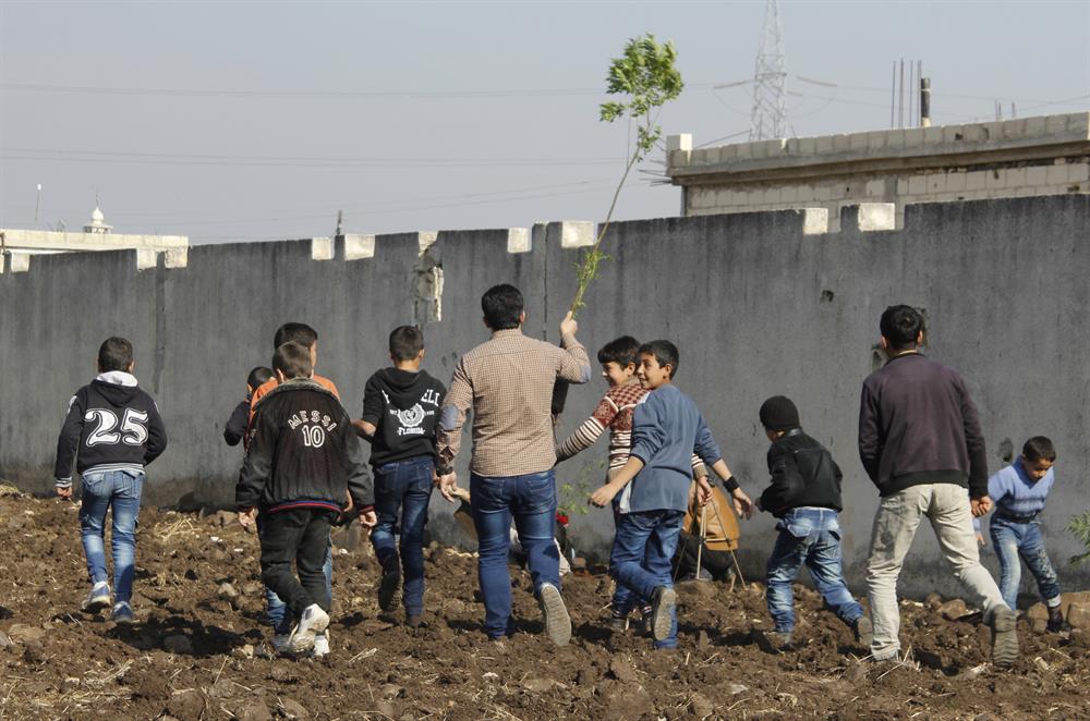 Syrian kids plant trees during the event named 'We plant future' in the towns besieged by Assad Regime in Homs, Syria on January 3, 2018.​