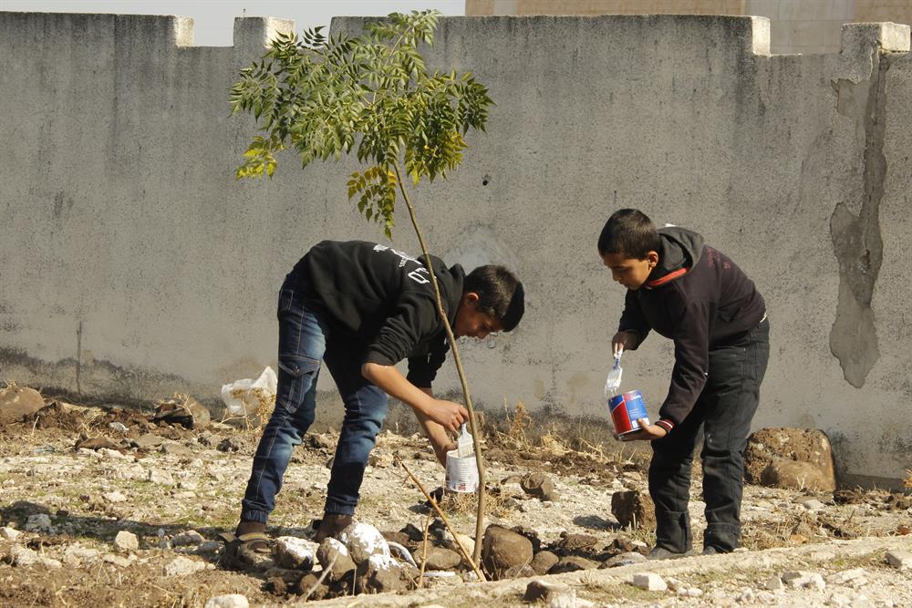Syrian kids plant trees during the event named 'We plant future' in the towns besieged by Assad Regime in Homs, Syria on January 3, 2018.​