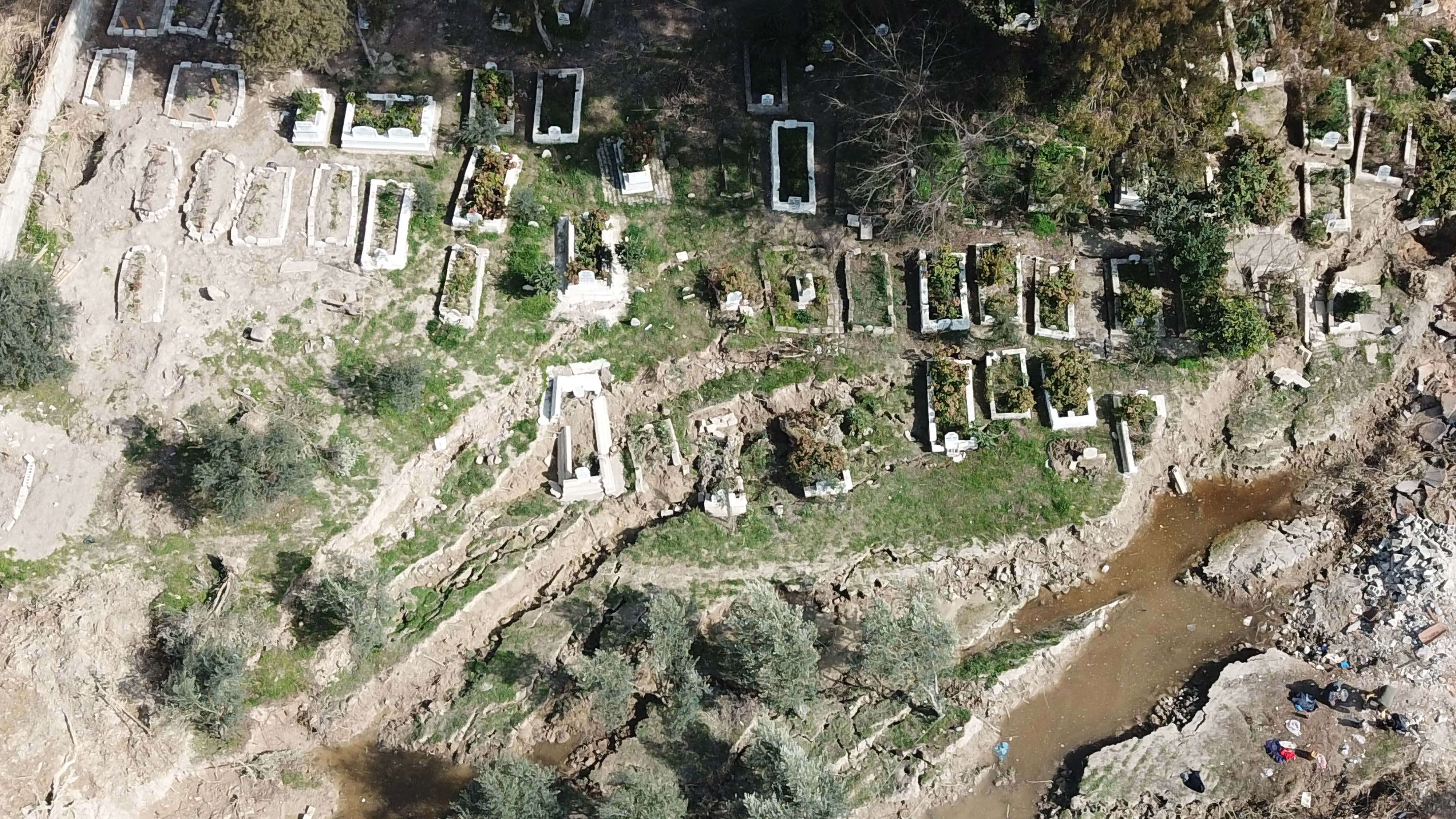 Depremler Hatay'da mezarlığı tahrip etti: 50 mezarın Asi Nehri'nde kaybolduğu iddia edildi