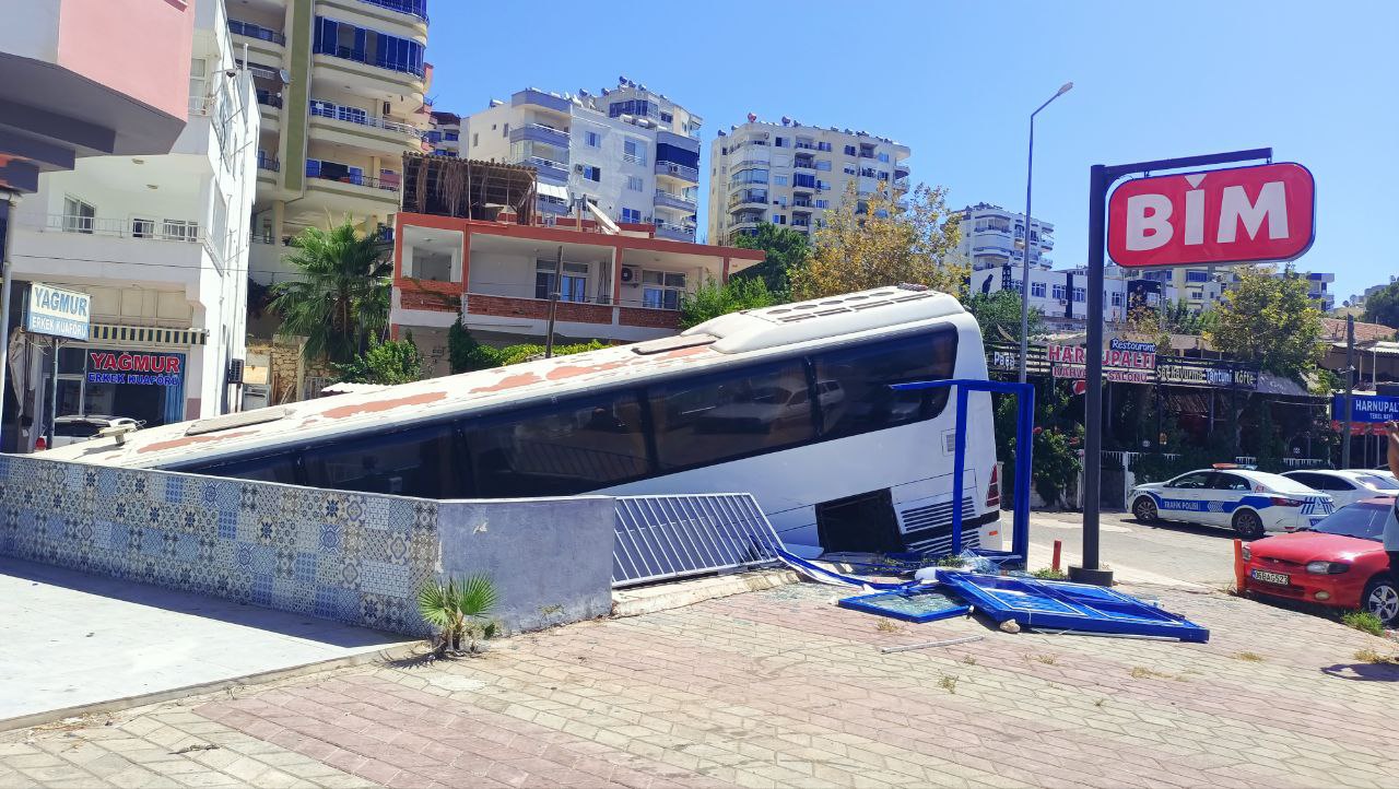 Park halindeki freni arızalandı: Otobüs otomobile çarpıp markete girdi